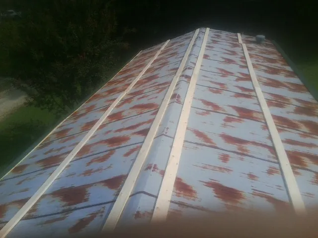 Rusted metal roof panels with new wood purlins before replacement — Storm Damage Roof Repair in Matherville by Roofing Brothers