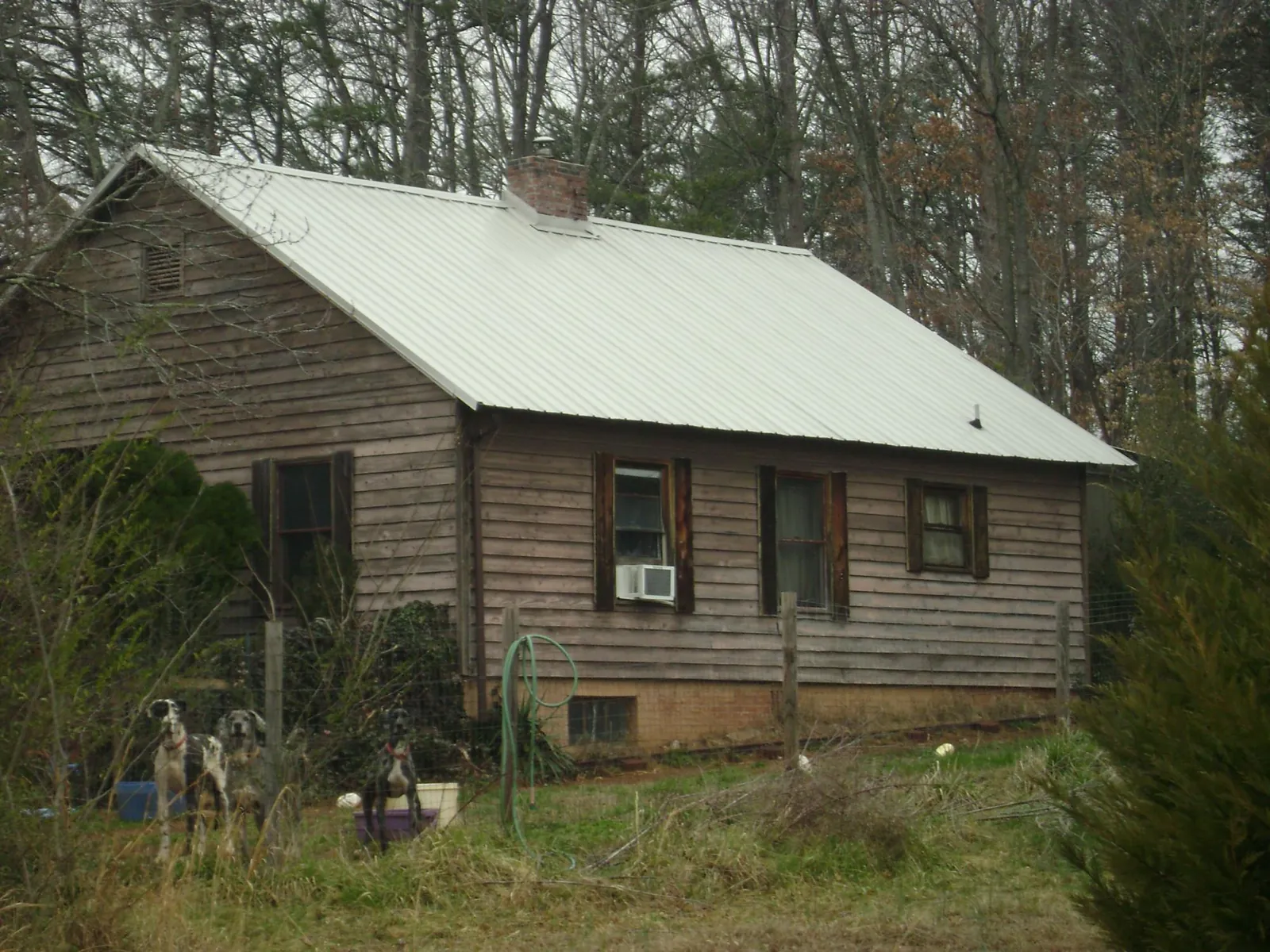 White metal roof on an old wood sided farmhouse, from a Metal Roof Installation job in Matherville
